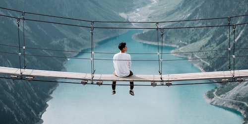 Man sitting on bridge in the alps