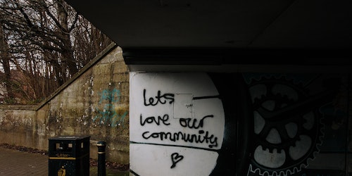 Alley way graffiti reads: 'let's love our community'